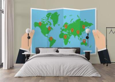 Hands hold folded paper map of world with markers Wall mural