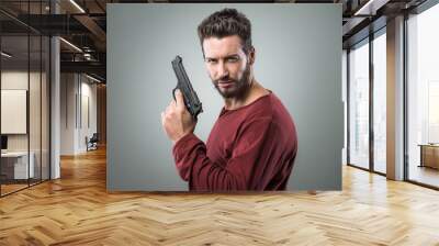 Cool young man holding a gun Wall mural