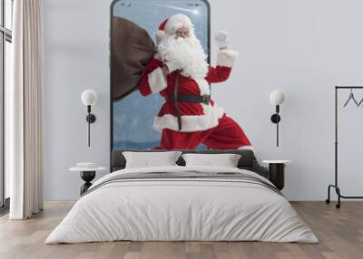 Fast Santa Claus running out of a Smartphone screen Wall mural