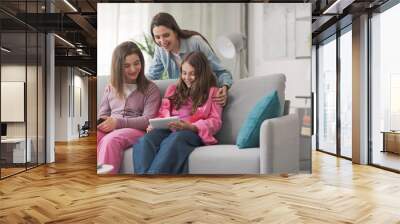 Mother and kids watching videos online together Wall mural