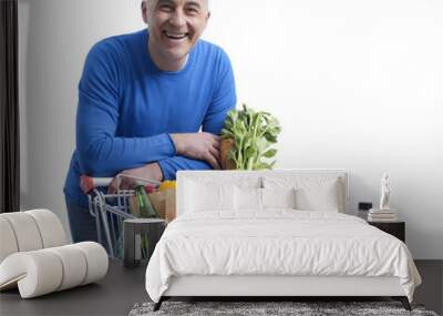 Smiling man posing with a shopping cart Wall mural