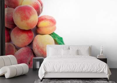 Heap of fresh ripe peaches with leaves on white background. Wall mural