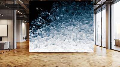 Pieces of crushed ice cubes on black background. Crushed ice heap with copy space. Wall mural