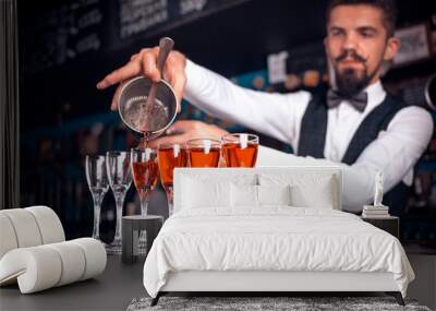 Charming bartending is pouring a drink while standing near the bar counter in bar Wall mural