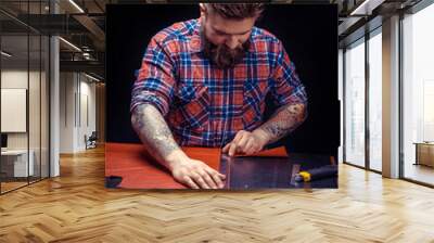 Craftsman working with leather works as an artisan at the tanner shop Wall mural