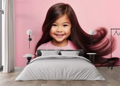 Smiling young brunette Korean child girl with healthy long hair Isolated on pink background. Wall mural