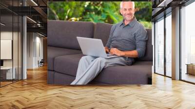 Man surfing the web on sofa Wall mural