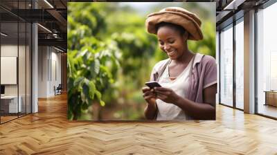 Young African woman using her phone in the agricultural farm. Wall mural