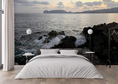 the sea waves crash on the rocks at sunset in the bay of Porto Conte
 Wall mural