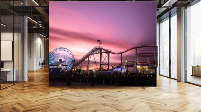 roller coaster and amusement wheel against a sunset sky at night Wall mural