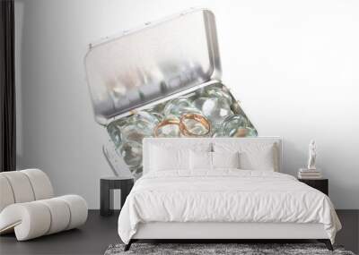 Two wedding rings on a transparent glass beads in a metal box is Wall mural