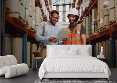 Bank manager showing loan options to warehouse manager using digital tablet in modern factory  Wall mural