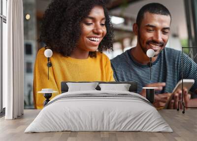 Cheerful young couple looking at smartphone Wall mural