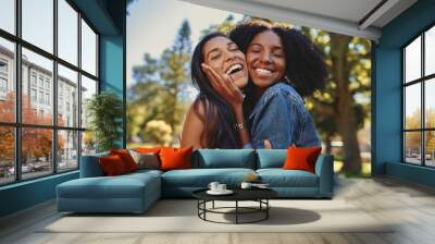 Close up lifestyle portrait of diverse multiracial happy best friends hugging each other and laughing in the park Wall mural