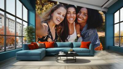 Close-up self portrait of smiling young multiethnic female friends taking selfie in the park - women taking a selfie in the park on a bright day Wall mural