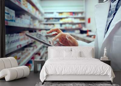 Closeup of hands of young female pharmacist checking inventory in medical store using digital tablet Wall mural