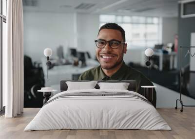 Friendly and smiling young african american professional businessman looking at camera in modern office Wall mural