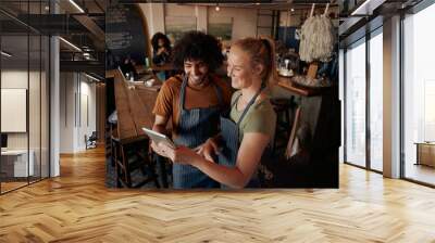 High angle view of young cafe owners standing using digital tablet wearing apron Wall mural