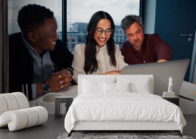 Multiethnic business team working together and looking on laptop screen at workplace Wall mural