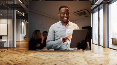 Portrait of an successful young african businessman using his digital tablet in meeting Wall mural