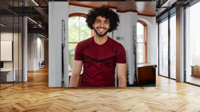 Portrait of confident young middle eastern man looking at camera at the gym Wall mural