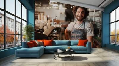 Portrait of handsome young male coffee shop owner standing behind counter Wall mural