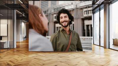 Portrait of successful and laughing business man in conversation with female partner on city street Wall mural