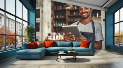 Smiling male cafe owner holding digital tablet in his hand Wall mural