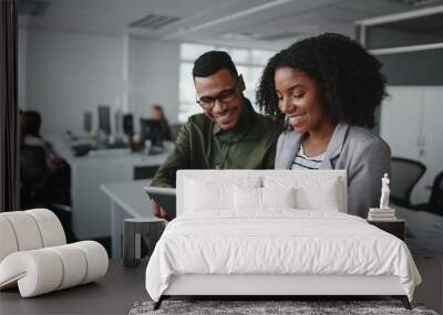 Smiling young african american professional businessman and businesswoman together working online with a digital tablet in office Wall mural