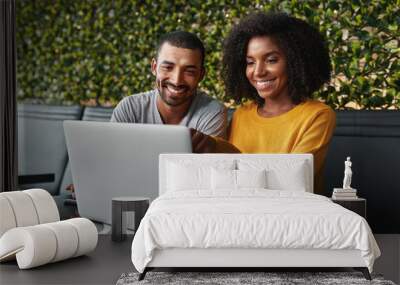 Young couple in café looking at laptop Wall mural