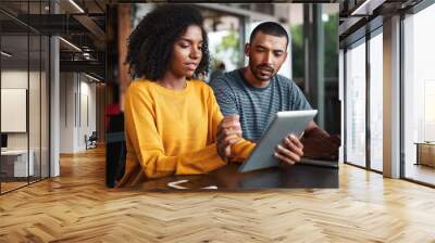 Young couple looking at digital tablet in cafe Wall mural