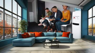 Young woman looking confident while sitting with a diverse group of job applicants in an office waiting for interviews Wall mural