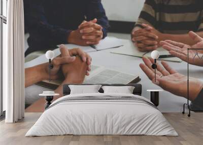 Christian groups sitting within the Church. Studying the word of God in churches. devotional or prayer meeting concept. Group of interlocked fingers praying together Wall mural