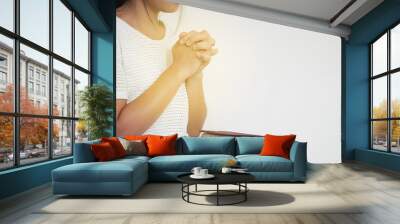 Close-up women christian read bible. Hands folded in prayer on a Holy Bible on wooden table. Wall mural