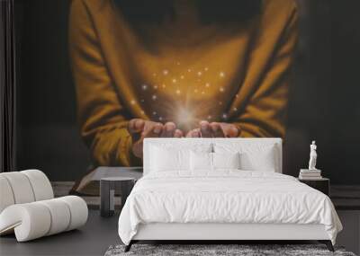 Woman praying on holy bible in the morning have a Yellow lights and sparkles coming. Woman hand with Bible praying. Christian life crisis prayer to god. Wall mural