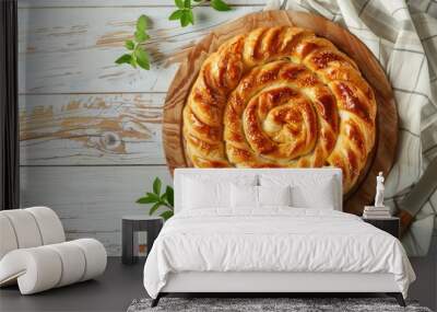 Burek made of filo dough with filling on cutting board, white wooden rustic background top view. Traditional savoury spiral pie of Balkans, Middle East and Central Asia. Wall mural