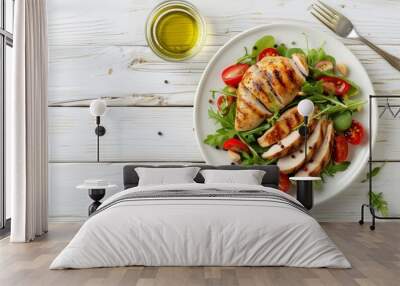 Healthy green vegetable salad with grilled chicken breast fillet on ceramic plate with olive oil on the side on white wooden kitchen table top view flat lay, diet food concept with space for text. Wall mural