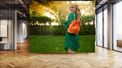 happy girl model in a green dress in the park. Fashion outdoor shooting. Wall mural