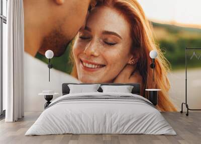 A happy couple in love posing. Wheat field. Freckled face. Pretty young family. Natural beauty. Wall mural