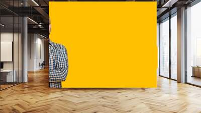 Blonde man looking through eyeglasses while touching his chin and thinking about something on a yellow wall with free space Wall mural