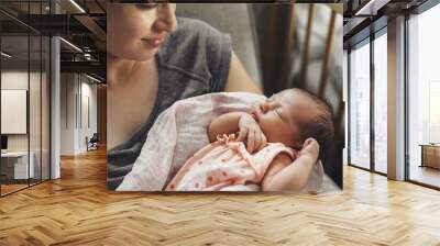 Caucasian mother with freckles is smiling at her newborn daughter while she is sleeping feeling safe Wall mural