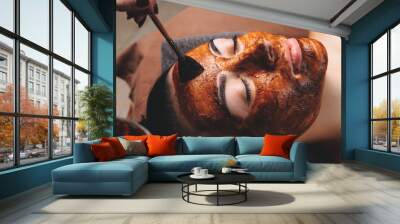 Caucasian woman having a facial care treatment with a cacao mask applied at the spa salon Wall mural