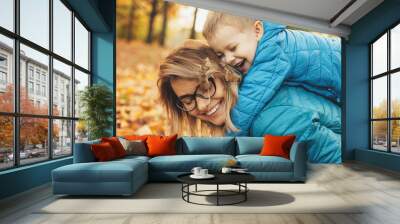 Side view portrait of a cute little kid playing with his mother sissint on her back laughing otudoor . Wall mural