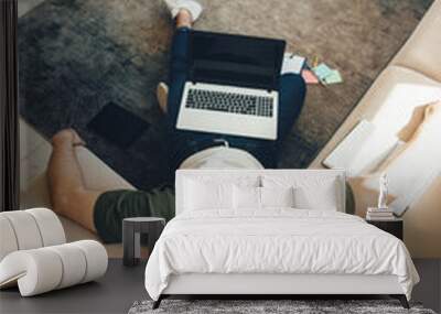 tired caucasian man with bristle lying on floor and sofa after working at the laptop with a book Wall mural