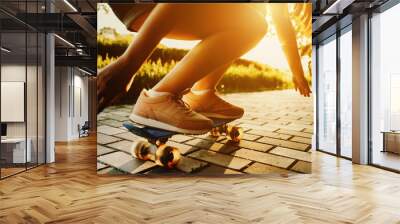 Young woman practising on skateboard in a park. Close up portrait of woman's legs on skate. Wall mural