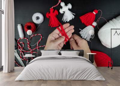 Woman making handmade traditional martisor, from red and white strings with tassel. Symbol of holiday 1 March, Martenitsa, Baba Marta, beginning of spring in Romania, Bulgaria, Moldova Wall mural