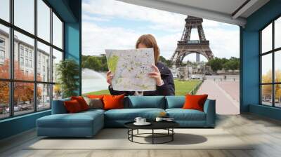 image of young female tourist with map looking for a way in pari Wall mural