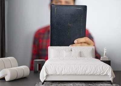 Believer man holding bible book on chest Wall mural