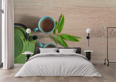 Tea time concept in asian style. Two chinese cups of tea, iron teapot and bamboo leaves on wooden background. Space for text, top view Wall mural