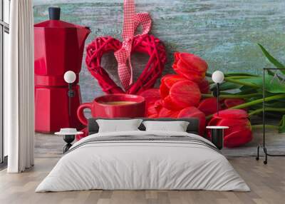 Valentine's day holiday concept; Red cup of coffee, bunch of red tulips, wicker heart and geyser coffee maker on old wooden background Wall mural